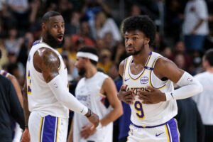 LeBron James junto a Bronny durante el encuentro de este domingo en la pretemporada de la NBA.